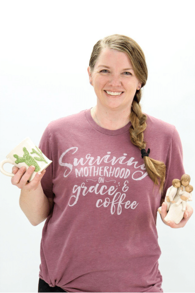 Woman in purple shirt holding dental products, smiling against white background.