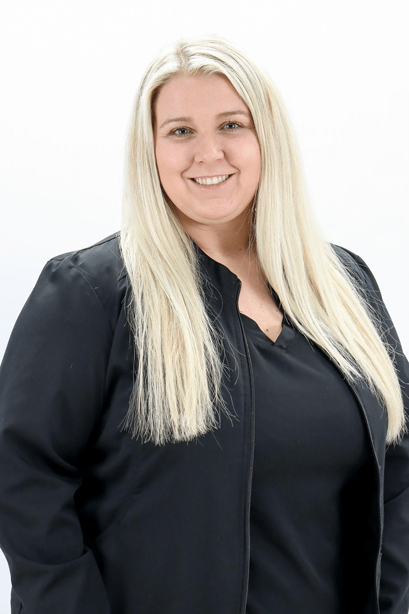 Professional headshot of a woman with blonde hair wearing dark blazer against white background.