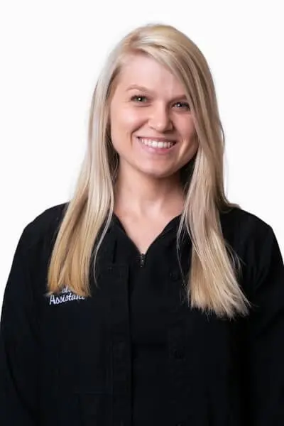 Chelsea T, dental assistant at Peachtree City dental practice, smiling in professional black uniform.