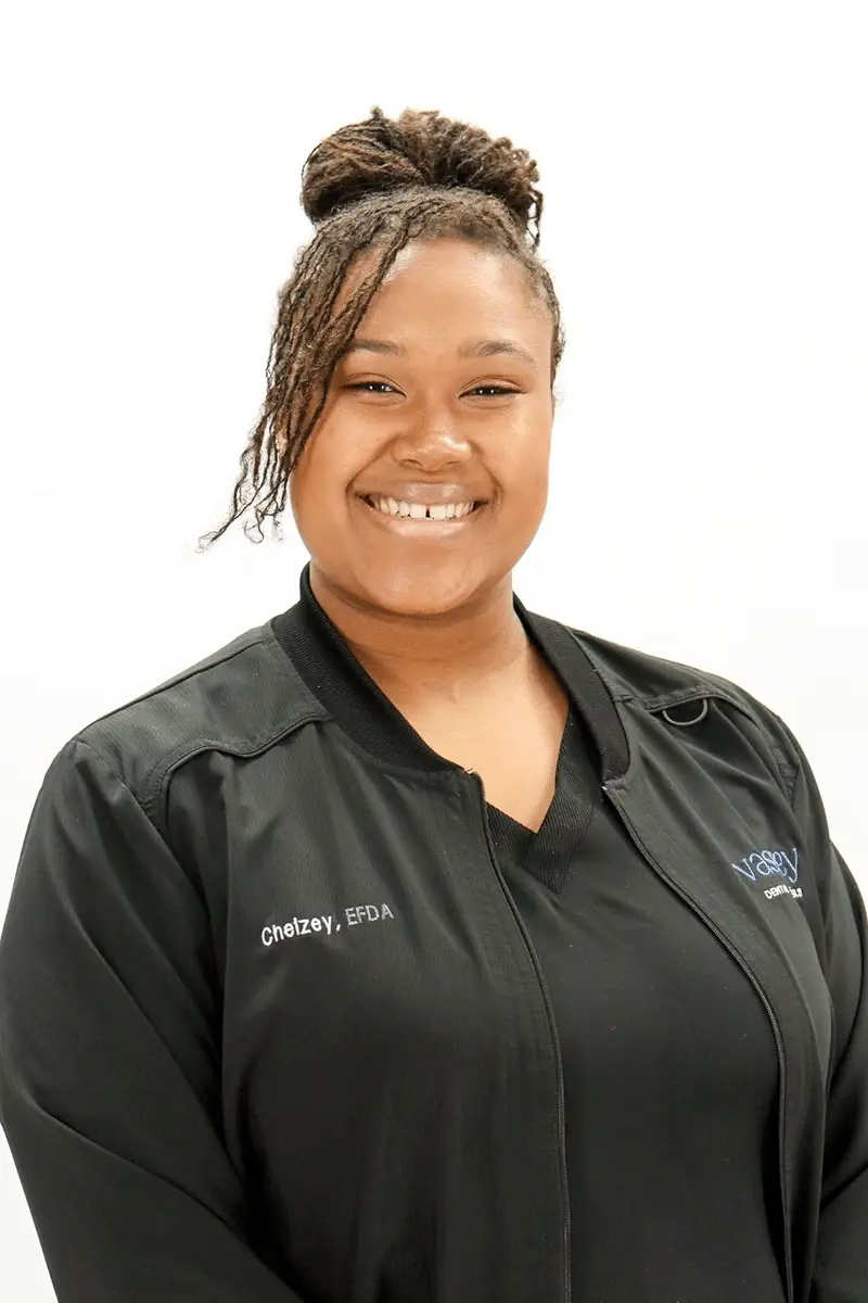 Chelzey, EFDA, smiling dental professional in black scrubs at Peachtree City practice.