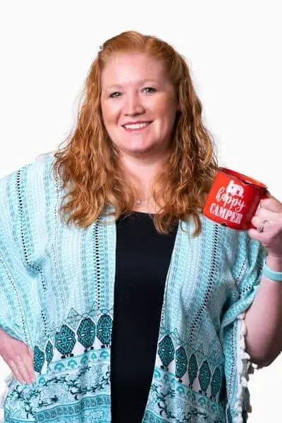 Smiling woman holding red mug at Peachtree City dental practice.