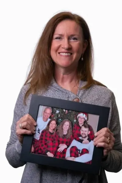 Diane M smiles while holding a family photo at Peachtree City dental practice.
