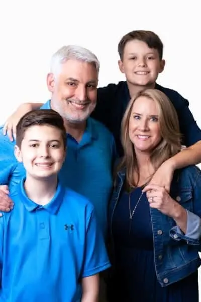 Dr. Neal M smiles with his family of four in professional portrait at Peachtree City dental practice.