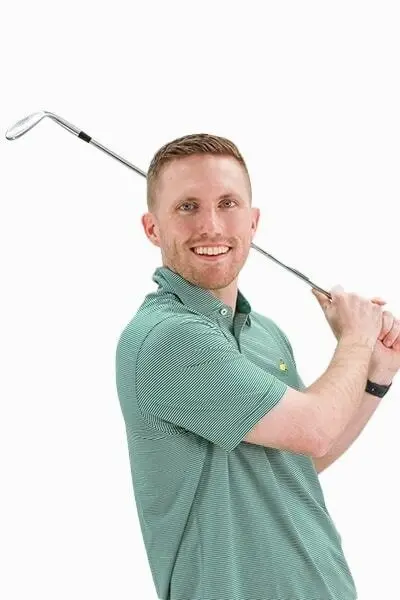 Male dentist in green polo shirt holding golf club, smiling at camera.