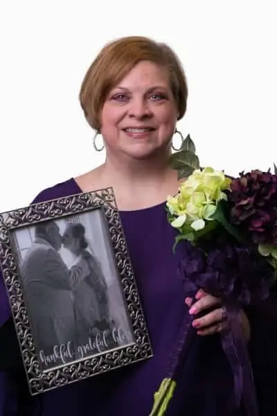Kristi M, team member at dental practice in Peachtree City, GA, smiling with flowers.