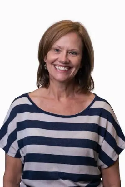 Kristi smiles warmly while wearing a striped navy and white top at Peachtree City dental practice.