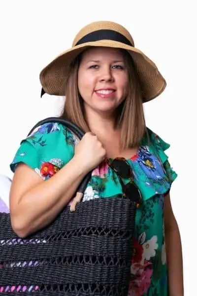 Smiling woman wearing a colorful floral shirt and straw hat at dental practice in Peachtree City.