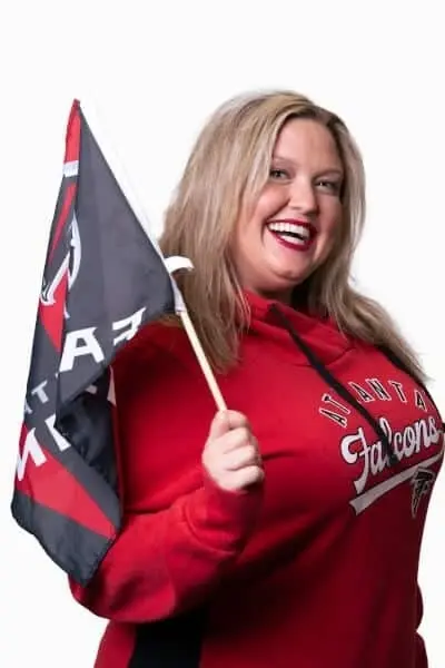 Woman in red dental practice apparel holding a flag at Peachtree City dental office.