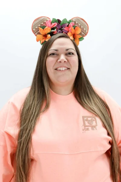 Jennifer smiling at Peachtree City dental practice wearing fun flower mouse ear headband.