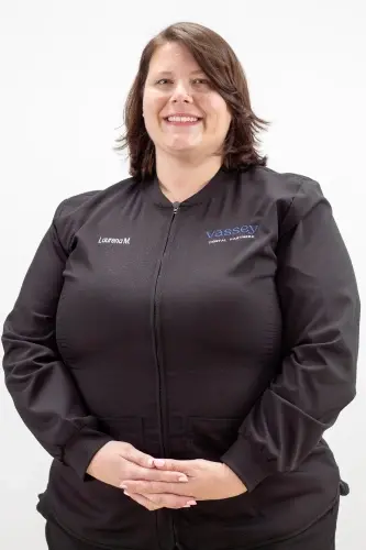 Laurena M., team member at dental practice in Peachtree City, GA, smiling in professional black jacket.