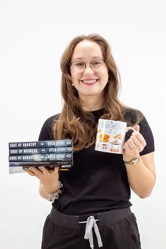 Rachel A. displays her published books while smiling at the dental practice in Peachtree City.